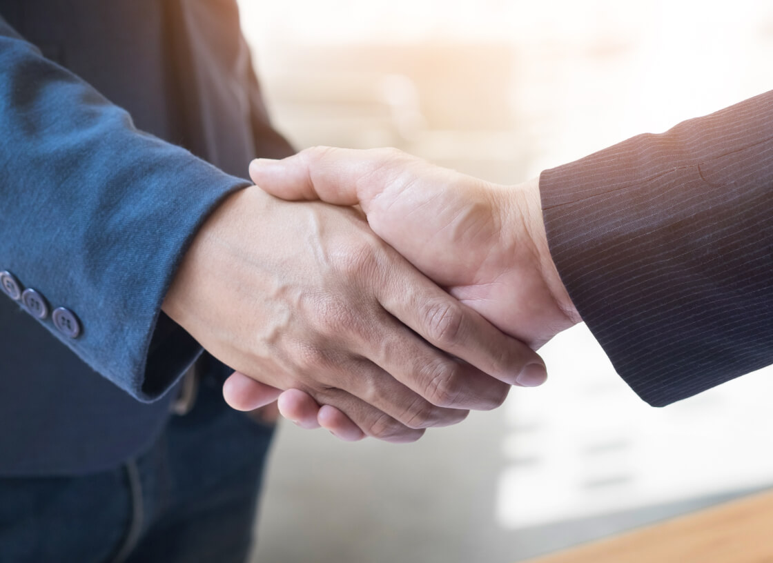 two confident business man shaking hands